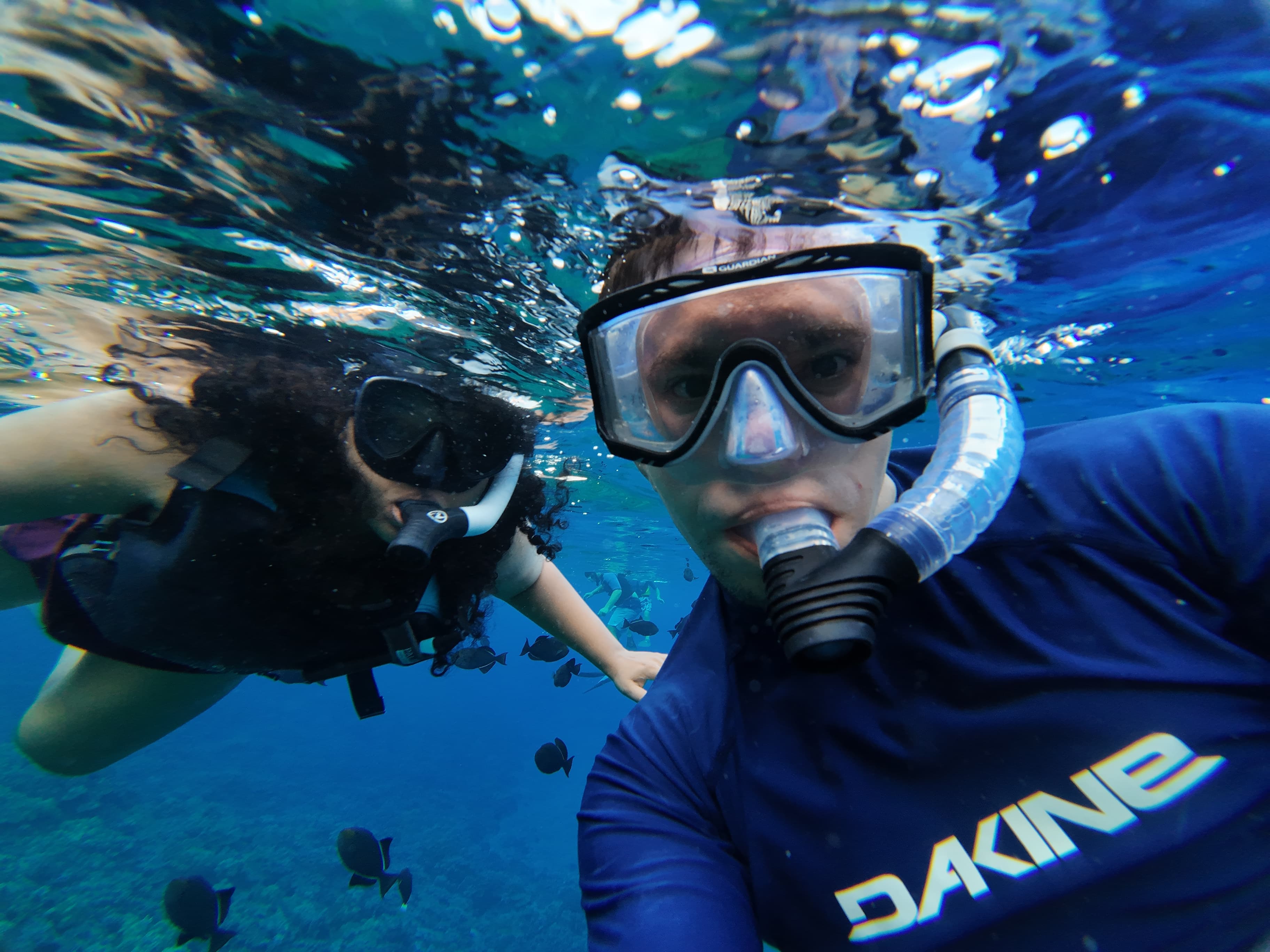 Gayatri and Oleg taking an underwater selfie while snorkeling among fish